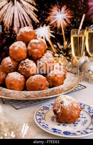 "Oliebollen", traditionelle holländische Blätterteig für Silvester. Mit Champagner und Feuerwerk im Hintergrund. Stockfoto