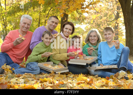 Familie Pizza essen im park Stockfoto