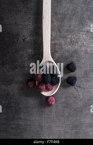 bunte Jelly Bonbons in Löffel auf Holztisch, von oben Stockfoto