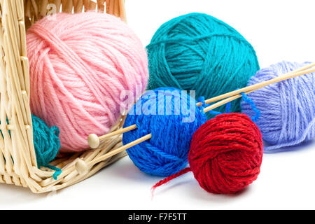 Colorful yarn balls falling out of basket and knitting needles, isolated on white background Stockfoto