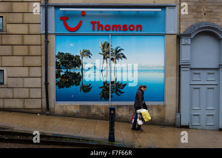 Huddersfield, UK. 30. November 2015. Eine Frau zu Fuß vorbei an einem Plakat in einem Thomson Travel Agents zeigt eine Sonne verwöhnten Insel mit Palmen. Bildnachweis: West Yorkshire Bilder/Alamy Live-Nachrichten Stockfoto