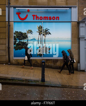 Huddersfield, UK. 30. November 2015. Menschen zu Fuß vorbei an einem Plakat in einem Thomson Travel Agents zeigt eine Sonne herrlich sonnigen Insel mit Palmen. Bildnachweis: West Yorkshire Bilder/Alamy Live-Nachrichten Stockfoto