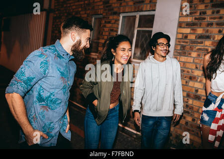 Multi-ethnischen Gruppe von Freunden plaudern und Lachen auf der Party. Junge Männer und Frauen zusammen auf Party auf dem Dach hängen. Stockfoto