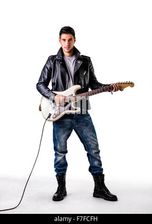 Full Length Portrait von junge Mann mit Lederjacke und Kampf Stiefel im Studio mit weißen Zeitmessung spielt e-Gitarre Stockfoto