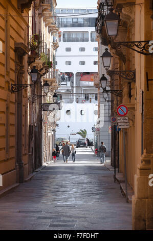 Sizilien Tourismus, Blick auf eine Gruppe von Familien erkunden eine schmale Straße in der Altstadt von Trapani, Sizilien. Stockfoto