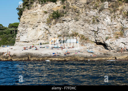 Sonnenanbeter genießen einen schroffen Felsenstrand entlang der Küste von Sorrento, Compania, Italien Stockfoto