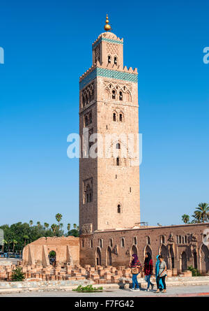 Vier Frauen vorbei an La Koutoubia-Moschee in Marrakesch, Marokko. Stockfoto