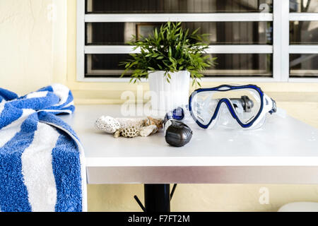 Eine nasse Schnorchel und Maske und ein Badetuch liegt auf einem Tisch mit einer Sammlung von Strand Rocks. St. Croix, Amerikanische Jungferninseln. Stockfoto