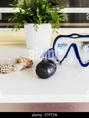 Eine nasse Schnorchel und Maske liegt auf einem Tisch mit einer Sammlung von Strand Rocks. St. Croix, Amerikanische Jungferninseln. Stockfoto