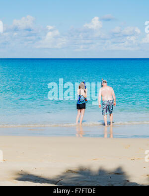 Ein 50 Jahre altes Paar waten bis zum Strand und zum Schnorcheln in der Karibik vor St. Croix, Amerikanische Jungferninseln vorbereiten. US Virgin Islands, USVI, U.S.V.I. Stockfoto