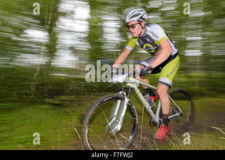 Ein Mountainbiker reitet durch den Wald auf einem Mountain Bike Wettbewerb Stockfoto