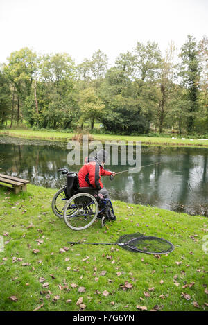 Ein behinderter Mensch fischt aus dem Rollstuhl Stockfoto