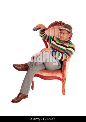 Ein Hispanic Mann, sitzt in einem rosa Sessel spielen mit der tv-Fernbedienung für weißen Hintergrund isoliert. Stockfoto