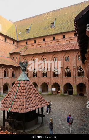 Hof mit Arkaden und Galerien in der mittelalterlichen Burg des Deutschen Ordens in Malbork (Marienburg), Polen. Stockfoto
