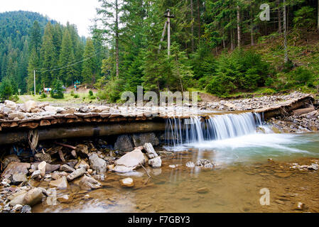Bergbach im Wald mit kleinem Wasserfall Stockfoto