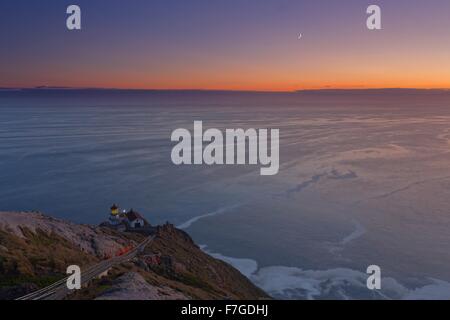 Weitwinkel-Blick auf den Leuchtturm am Point Reyes National Seashore bei Sonnenuntergang mit Venus und Mondsichel. Stockfoto