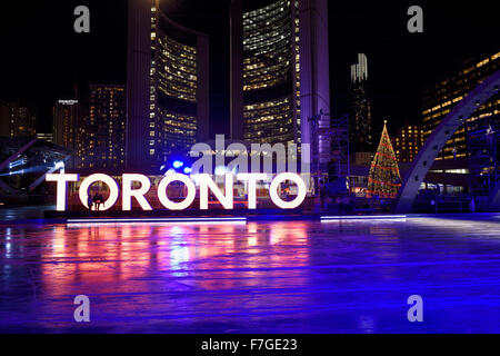 Eisbahn am Nathan Phillips Square bei Nacht mit Rathaus und Toronto Zeichen Stockfoto