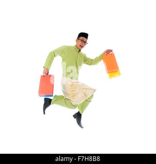 Traditionelle malaiische männlichen Einkaufs- und springen in Freude während Hari Raya Ramadan festival Stockfoto