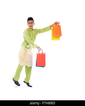 Traditionelle malaiische männlichen Einkaufs- und springen in Freude während Hari Raya Ramadan festival Stockfoto