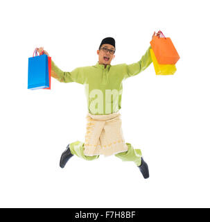 Traditionelle malaiische männlichen Einkaufs- und springen in Freude während Hari Raya Ramadan festival Stockfoto