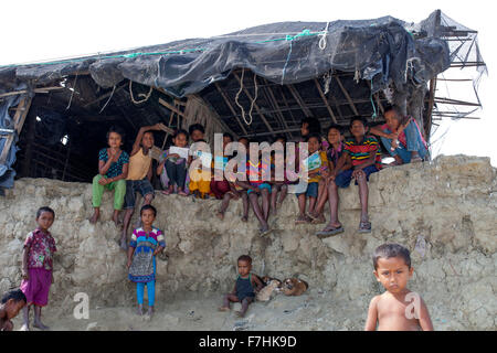 COX BAZAR, Bangladesch - November 29: Kinder im Klimawandel und den Meeresspiegel ansteigen betroffen gebrochen Haus in Kutubdia Insel von Cox Bazar Viertel am 29. November 2015.  Kutubdia, eine Insel vor der Cox Bazar Küste. die Widrigkeiten der Natur ausgelöst vor allem durch Klima ändern. In den letzten zwei Jahrzehnten wurden die Auswirkungen des Klimawandels in Bangladesch Beschleunigung. Kutubdia ist auch schwer getroffen. Der Platz ist sehr anfällig für Wirbelstürme und Sturmfluten, die häufige und intensive in Bangladesch sowie steigender Meeresspiegel und stärkeren Wellen geworden sind. Das Ergebnis sind massive erosio Stockfoto