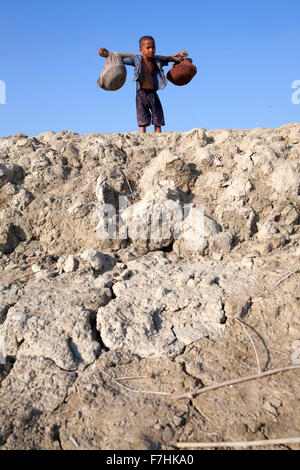 COX BAZAR, Bangladesch - November 29: Kinder, die Mittagessen für ihren Vater in Kutubdia Insel im Cox Bazar Viertel am 29. November 2015.  Kutubdia, eine Insel vor der Cox Bazar Küste. die Widrigkeiten der Natur ausgelöst vor allem durch Klima ändern. In den letzten zwei Jahrzehnten wurden die Auswirkungen des Klimawandels in Bangladesch Beschleunigung. Kutubdia ist auch schwer getroffen. Der Platz ist sehr anfällig für Wirbelstürme und Sturmfluten, die häufige und intensive in Bangladesch sowie steigender Meeresspiegel und stärkeren Wellen geworden sind. Das Ergebnis sind massive Erosion und Salininty eindringen, nicht nur de Stockfoto
