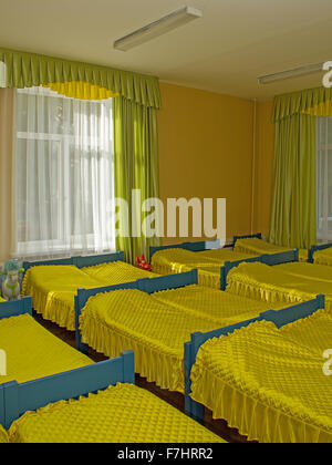 Reihen von Betten im Kindergarten gelbe Schlafzimmer Stockfoto