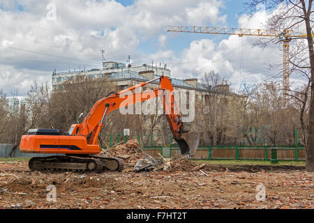 Raupenbagger entfernt Bauschutt nach Gebäudeabbruch Stockfoto