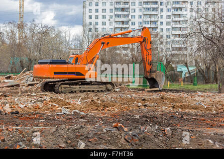 Raupenbagger entfernt Bauschutt nach Gebäudeabbruch Stockfoto
