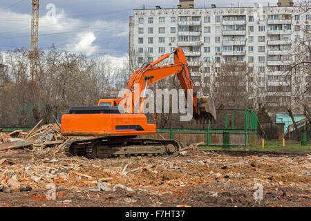 Raupenbagger entfernt Bauschutt nach Gebäudeabbruch Stockfoto