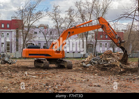 Raupenbagger entfernt Bauschutt nach Gebäudeabbruch Stockfoto