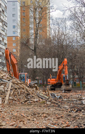 Raupenbagger entfernt Bauschutt nach Gebäudeabbruch Stockfoto