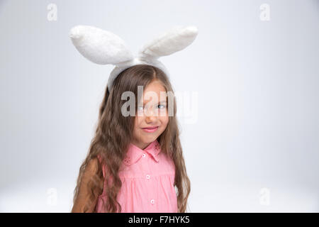 Porträt eines glücklichen Mädchens mit Hasenohren, Blick in die Kamera auf einem weißen Hintergrund isoliert Stockfoto