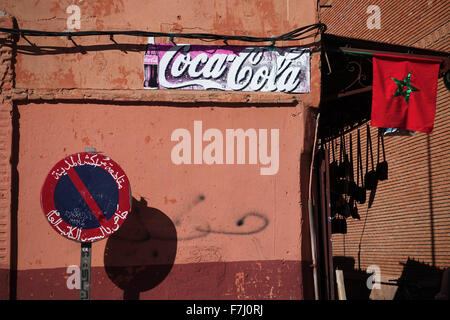 Marrakesch, Marokko. 7. November 2015. Die Coca-Cola-Bezeichnung auf eine Mauer zwischen ein Stop-Schild und die marokkanische Flagge in der alten Stadt Marrakesch, Marokko, 7. November 2015. Foto: Jens Kalaene - NO-Draht-SERVICE-/ Dpa/Alamy Live News Stockfoto