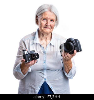 Ältere Frau mit alten analogen und moderne Digitalkameras in Händen, Wahl-Konzept Stockfoto