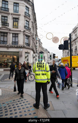 Ein schwarzer Mann, der eine hohe visiblity Jacke und Hut Werbung ein Golf Verkauf in der Regent Street, London, England, Großbritannien Stockfoto