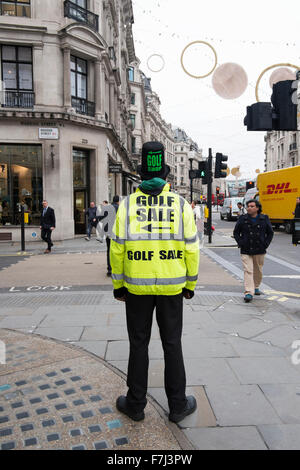 Ein schwarzer Mann, der eine hohe visiblity Jacke und Hut Werbung ein Golf Verkauf in der Regent Street, London, England, Großbritannien Stockfoto