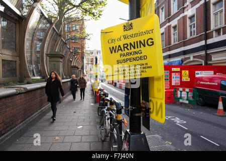 Gelbe Schilder, die durch die Stadt von Westminster Warnung, dass der Stellplatz in Wardour Street, Soho, London, England, Großbritannien Stockfoto