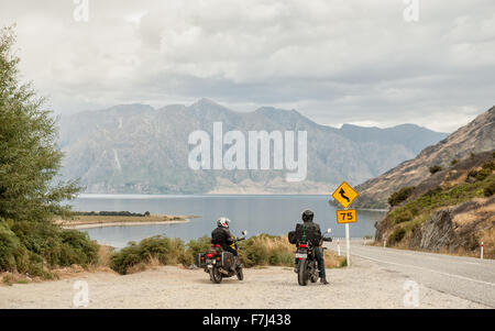 Motorradfahrer bewundern Sie die Aussicht auf Lake Hawea in Central Otago, Südinsel, Neuseeland. Stockfoto