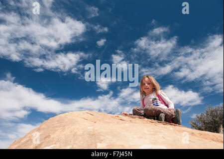 Kleines Mädchen sitting on Top of Rock, Porträt Stockfoto