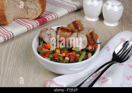 Scheiben von hausgemachten Wurstwaren mit Gemüse Stockfoto
