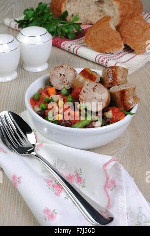 Scheiben von hausgemachten Wurstwaren mit Gemüse Stockfoto