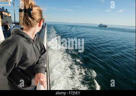 Frau steht auf Deck der Fähre, auf der Suche über die Schulter auf den Blick Stockfoto