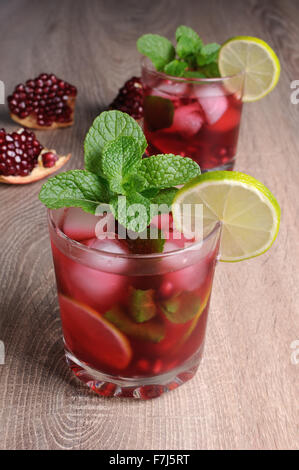 Granatapfel-cocktail mit Scheiben Limette, Minze und Eis Stockfoto