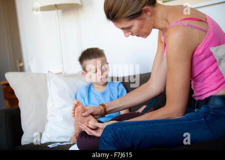 Reportage über Fußreflexzonenmassage für Kinder. Die Reflexologin befasst sich mit Kindern im Alter von 5 aufwärts. Reflexzonenmassage wirkt auf ihre Konzentration, Gedächtnis, Balance, Ruhe und Schlaf. Ein 5 - Jahre alter Junge in einer Sitzung. Stockfoto