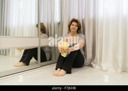 Müde von der Reinigung Hausfrau am Boden Stockfoto