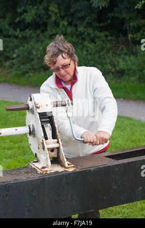 Frau, die im August Schleusentore bei Caen Hill Locks, Kennet und Avon Canal, Devizes, Wiltshire, England, UK, bediente Stockfoto