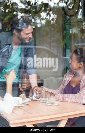 Kellner im Gespräch mit Kunden in Coffee-shop Stockfoto