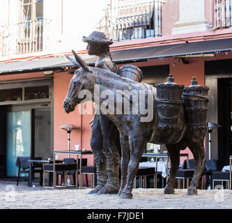 Statue eines Mannes und eines Esels in der Nähe von Kathedrale von Granada in Spanien vor einer spanischen Bar mit Tischen und Stühlen Stockfoto