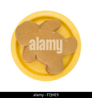 Ansicht von oben aus einem Stapel von frisch gebackenen Lebkuchenmänner auf eine kleine gelbe Pappteller isoliert auf einem weißen Hintergrund. Stockfoto